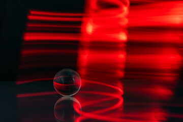 Abstract colorful irregular lines with glass bubble on black background and wall texture. Long exposure. Light painting photography.