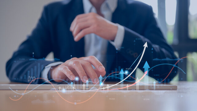 Businessman typing on keyboard working with arrow chart in percentage finance and investment concept, invest money, fundraising, ROI return on investment, Interest rate and dividend concept