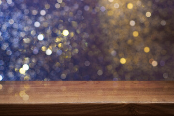 Empty wooden table festive background for your product montage with blurry fairy lights and sparkling smoke glows