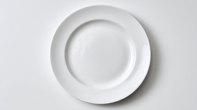 Minimalist white plate on bright white surface with soft studio lighting for a sleek tableware image