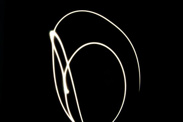 Abstract light trails on a black background. The image features curved lines and shapes created by light movement, emphasizing motion and energy.