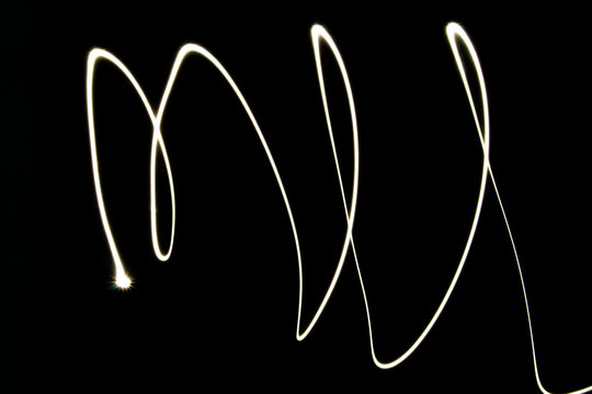 A light trail forms the letters 'ML' against a black background. The design is abstract and modern, showcasing creativity and artistic expression. - Powered by Adobe