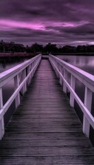 A serene view of a wooden bridge stretching across calm water under a dramatic sky, creating a pathway to tranquility and reflection.