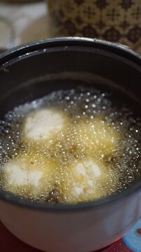 Traditional Indonesian snack combro being deep-fried in an electric fryer until golden and crispy.