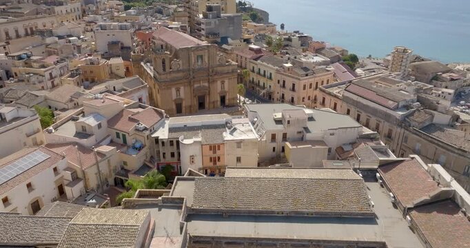 Aerial view of the Basilica of Maria Santissima del Soccorso. It's the main Catholic place of worship in Sciacca, province of Agrigento, Sicily, Italy. In background is the blue Mediterranean sea.