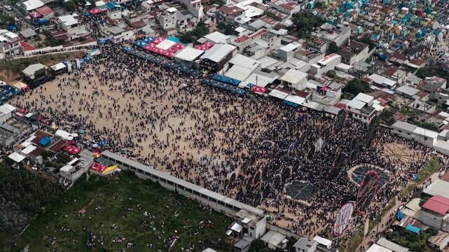 Aerial of Sumpango festival crowds and nearby colorful cemetery in Guatemala