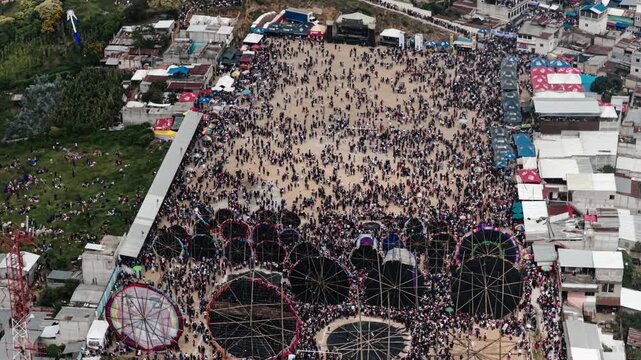 Top view of giant handmade kites surrounded by crowds at Sumpango festival