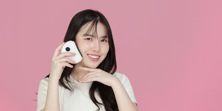 Skincare Routine. Young woman using beauty device for facial care.