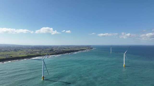 冬が近く風の強い富山湾沿岸の洋上風力発電風車や波のかかる離岸堤などの風景
