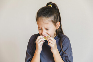 Cute little girl eating fresh lemon isolated on white background