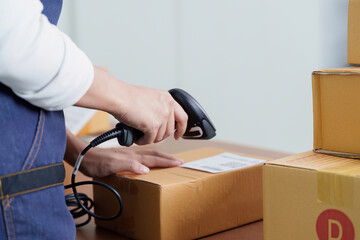 Inventory Management. Employee scanning package with barcode scanner in warehouse.