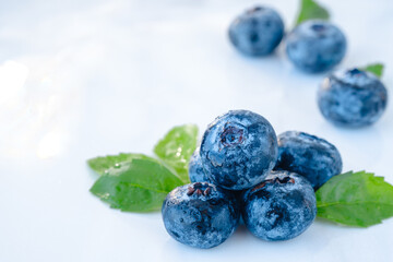 Fresh blueberries with green leaves on a white background. Forest wet berry close-up