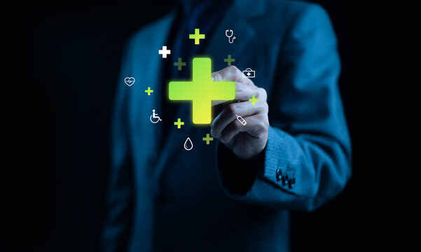 Businessman touching virtual medical cross icon with healthcare technology interface, representing digital health innovation, telemedicine, and future medical data management for modern care systems. - Powered by Adobe