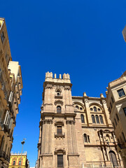 A sand-colored stone church with columns in the historic center. Spain, Malaga, 2022.
