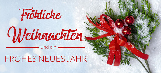 Weihnachtsgrüße: Grußkarte mit der Aufschrift FRÖHLICHE WEIHNACHTEN UND EIN FROHES NEUES JAHR vor hellem Hintergrund neben Tannenzweigen