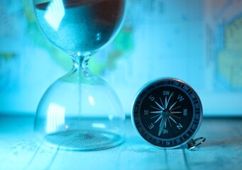 Compass and hourglass as symbols of time and travel adventure concept photo