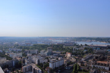 Panoramic view of industrial city with port and cranes on summer day