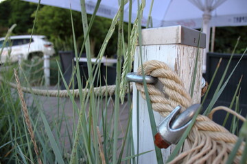 Rope fence with metal clamp and wooden post