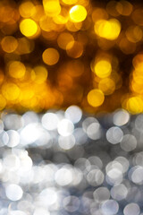 Abstract background with gold and silver bokeh lights. Soft, shimmering circles create festive and elegant atmosphere perfect for holiday designs, luxury branding, or celebration-themed visuals