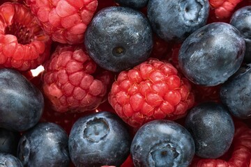 Close up of fresh ripe raspberries and blueberries in a vibrant mix