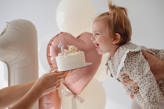 Cute one-year-old girl celebrating birthday with balloons and festive decor
