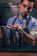 Professional bartender pouring spirit