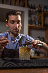 Bartender pouring liquid into cocktail glass