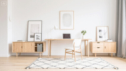Blurred modern minimalist home office interior with bright white walls, warm wood furniture, and soft focus. Perfect for virtual meeting backgrounds, website design, and creative projects.