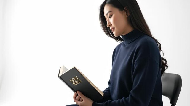 Asian woman reading Holy Bible with thoughtful expression, representing Christian faith and spiritual contemplation on white background