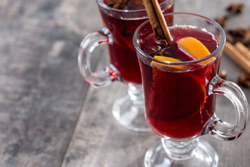 Mulled Wine with Orange and Cinnamon Sticks and Christmas decoration on wooden table. Copy space