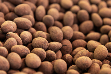 Close-up of brown dragee, chocolate covered nuts, sweet candy background.