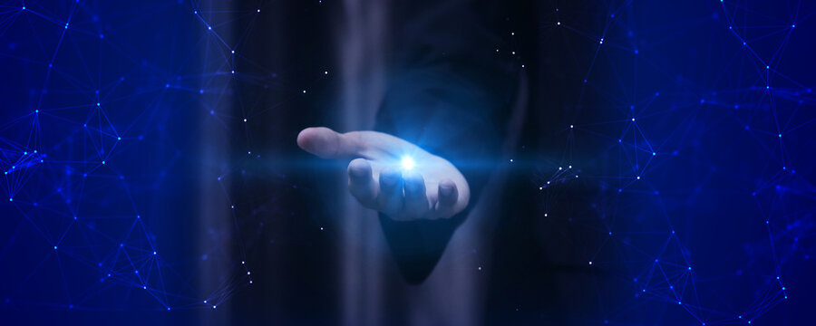 Futuristic digital concept of human hand holding glowing blue light surrounded abstract network connections representing innovation and advanced technology.