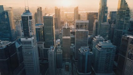 Aerial drone view of a sprawling modern cityscape at sunrise with towering glass skyscrapers reflecting the golden light of dawn creating a sense of urban progress - Powered by Adobe