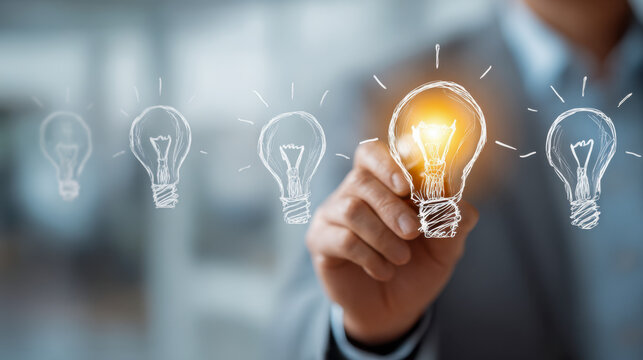 Businessman highlighting a glowing light bulb among unlit bulbs in a creative concept of innovation and unique ideas for success and inspiration in the workplace - Powered by Adobe