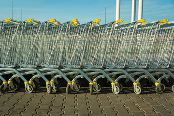 Row of large nested shopping carts on an outdoor store parking lot