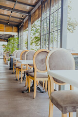 Elegant cafe terrace with wooden chairs and white tables for hospitality and dining concept