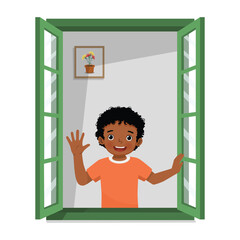 Little African boy opening window greeting waving hand in the morning
