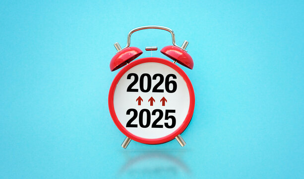 A red alarm clock with the numbers 2026 and 2025 on it