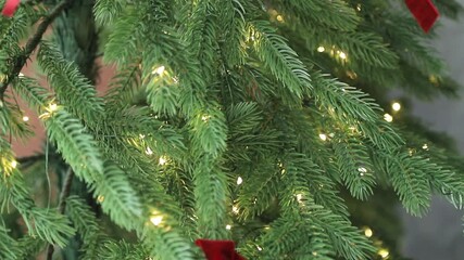 Decorated Christmas tree with red ribbons, and twinkling warm white led lights - Powered by Adobe