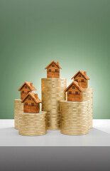 Miniature model house standing on a stack of coins