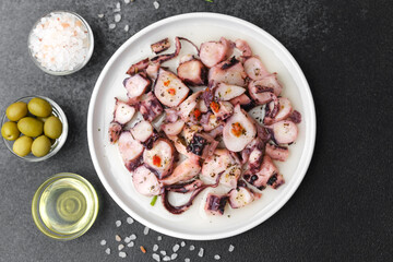 Octopus pieces in white bowl for salad preparation or healthy lunch concept
