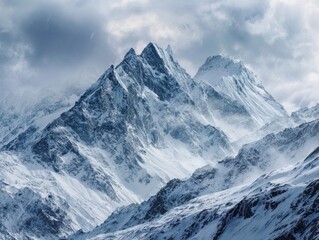 Obraz premium Dramatic Snowy Mountain Peaks Winter Landscape Cloudy Sky Majestic Alpine Scenery