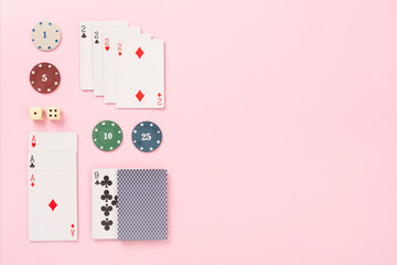 Poker chips and playing cards on color background, top view. Casino card game