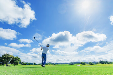 緑が綺麗なゴルフ場でプレイする人