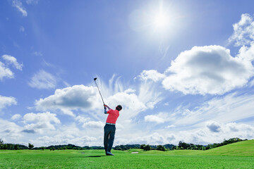 緑が綺麗なゴルフ場でプレイする人
