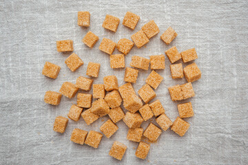 Cubes of brown sugar arranged on a linen surface for culinary use