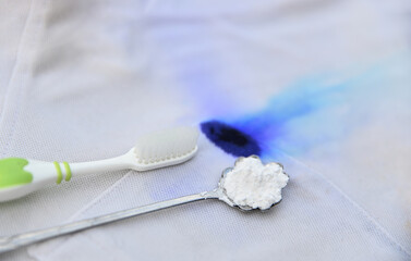 Baking soda powder on spoon with dirty ink stain preparing for clean dirt spot. dirty stains for cleaning concept idea