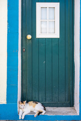 Calico cat resting on doorstep in Alcoutim, Portugal