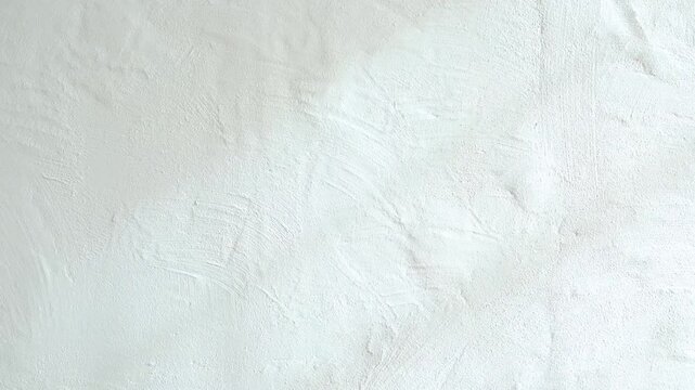 Textured white wall surface showing light shadows and subtle patterns