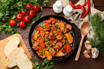 Delicious cooked stew served on wooden table, flat lay